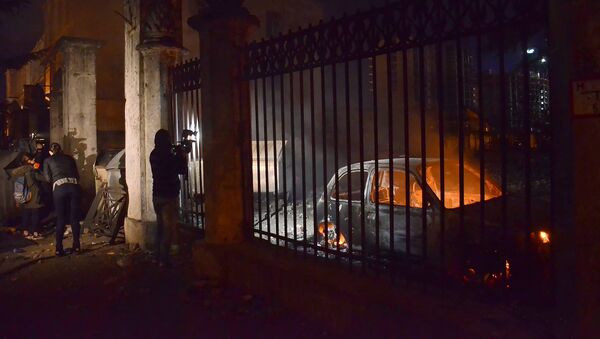 Оператор одного из грузинских телеканалов снимает сожженные в ходе беспорядков в Батуми машины - Sputnik Грузия