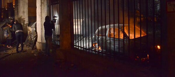 Оператор одного из грузинских телеканалов снимает сожженные в ходе беспорядков в Батуми машины - Sputnik Грузия