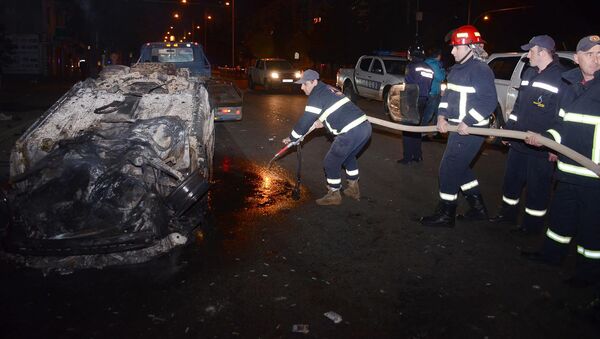 Пожарные тушат один из сожженных в ходе беспорядков в Батуми автомобилей - Sputnik Грузия