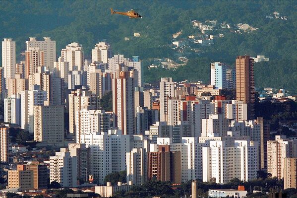 В Бразилии сегодня распространены летающие такси. Несмотря на высокую стоимость, популярность передвижения на маленьких самолетах или малолитражных вертолетах очень высока. Это обусловлено частыми пробками по всему городу. На фото - вертолет над Сан-Паулу, самым населенным городом не только в Бразилии, но и на всем южном континенте. - Sputnik Грузия