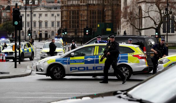 Вооруженные сотрудники полиции организовывают оцепление и перекрывают дороги у Вестминстерского моста неподалеку от здания Парламента в Лондоне - Sputnik Грузия