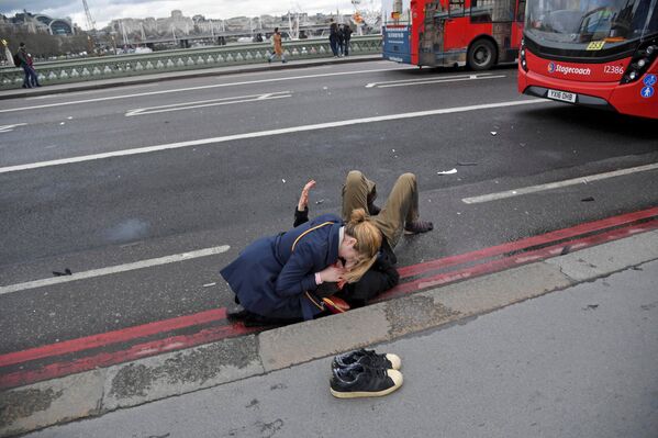 Женщина помогает раненому в результате теракта у Вестминстерского моста в Лондоне - движение машин через мост сразу было остановлено - Sputnik Грузия
