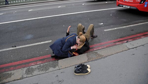 Женщина помогает раненому в результате стрельбы у Вестминстерского моста в Лондоне - Sputnik Грузия
