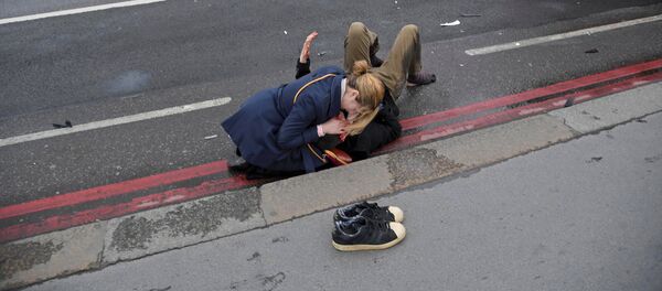 Женщина помогает раненому в результате стрельбы у Вестминстерского моста в Лондоне - Sputnik Грузия