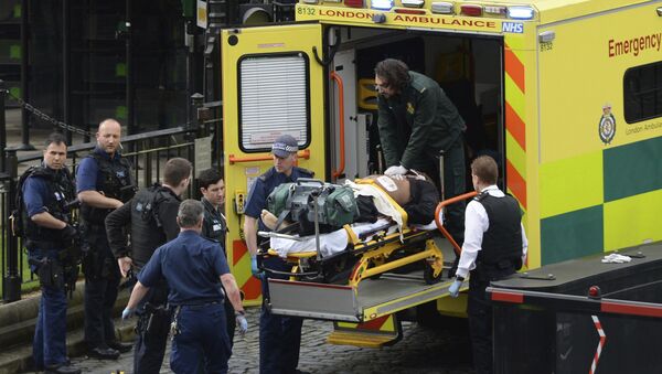 Сотрудники чрезвычайных служб увозят с места стрельбы у Вестминстерского моста в Лондоне раненых и пострадавших - Sputnik Грузия