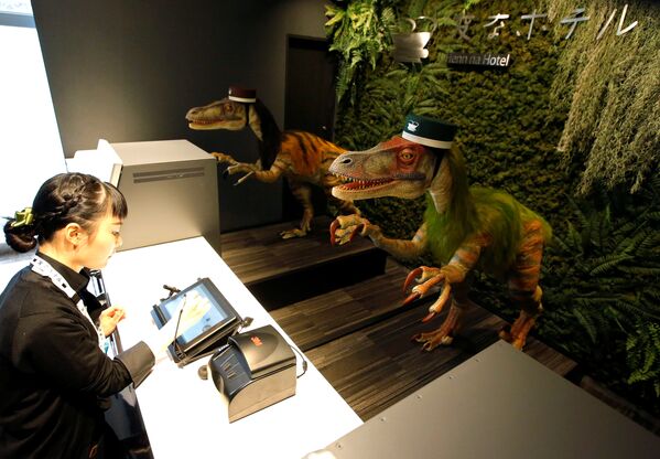 На регистрации в отеле Henn na Maihama Tokyo Bay в Японии установили роботов-динозавров. На фото - служащий отеля во время пресс-показа демонстрирует, как пройти регистрацию в отеле с помощью робота - Sputnik Грузия