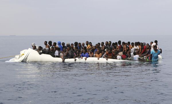 Мигранты ждут помощи после столкновения надувных лодок у ливийского прибрежного города Завия. На них беженцы пытались пересечь Средиземное море, направляясь в Европу - Sputnik Грузия