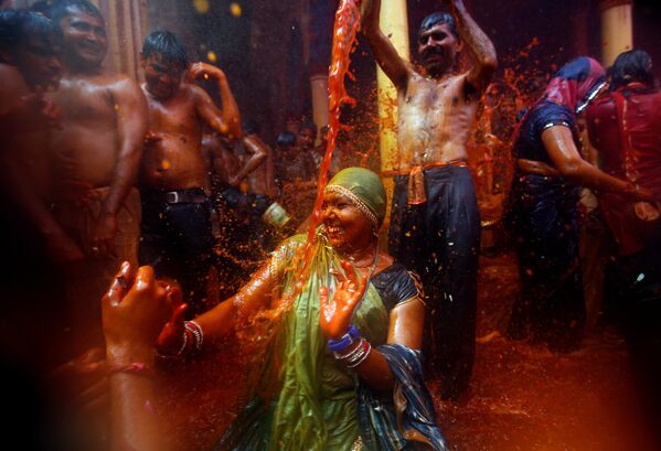 Мужчина поливает водой женщину во время Хуранга - игры, проводимой между мужчиной и женщиной через день после праздника Холи, в храме Дауджи недалеко от северного города Матхура в Индии - Sputnik Грузия