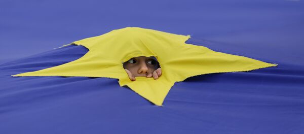 Ребенок смотрит через разрез, сделанный на одной из звезд, которые составляют флаг Европейского Союза, во время митинга поддержки, организованного в честь 60-летия Европейского Союза в Риме, в центре Бухареста, Румыния - Sputnik Грузия