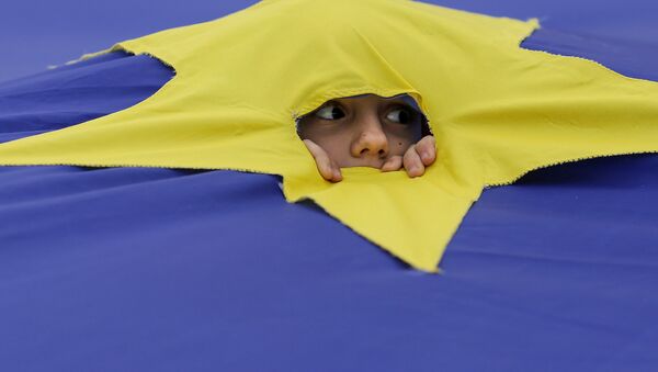 Ребенок смотрит через разрез, сделанный на одной из звезд, которые составляют флаг Европейского Союза, во время митинга поддержки, организованного в честь 60-летия Европейского Союза в Риме, в центре Бухареста, Румыния - Sputnik Грузия