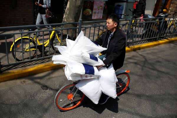 Мужчина на велосипеде везет домой подушки, на одной из улиц в Шанхае - Sputnik Грузия