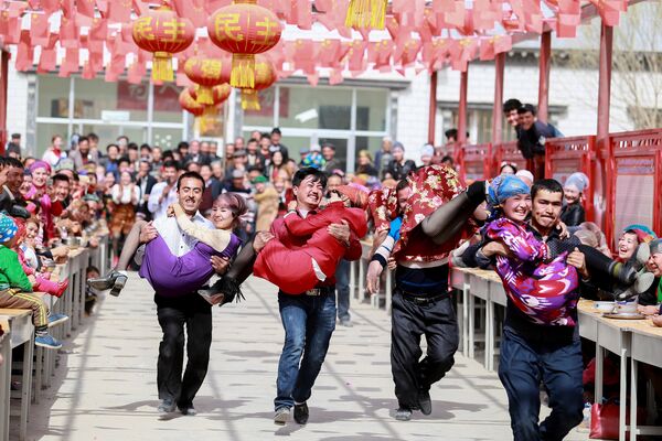 Мужчины бегут с женами на руках во время проведения одного из соревнований во время празднования Фестиваля Новруз в Аксу, Китай - Sputnik Грузия