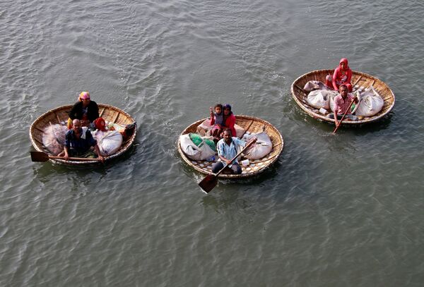 Рыбаки плывут на лодках с членами своих семей в водах озера Вембанад в Кочи, Индия. Озеро славится своими плавучими домами, или, как их там называют, Кеттувалламами. Их там огромное количество и они не только перевозят пассажиров с острова на остров, но и являются своеобразными мини-отелями - Sputnik Грузия