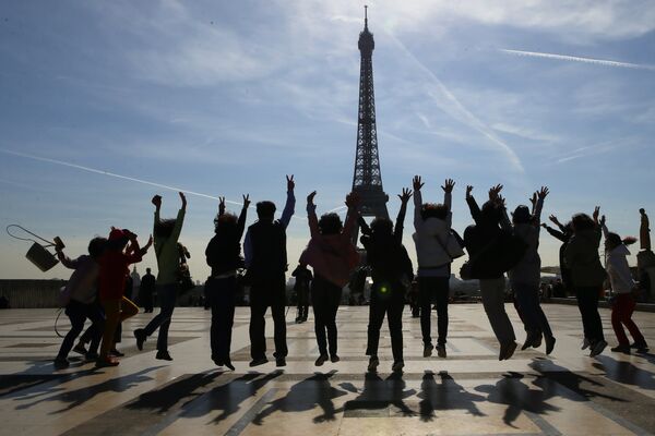 Туристы позируют на фоне Эйфелевой башни в солнечный день в Париже - Sputnik Грузия