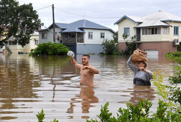 Местные жители идут по затопленному наводнением району Нового Южного Уэльса. Лисмор, Австралия - Sputnik Грузия