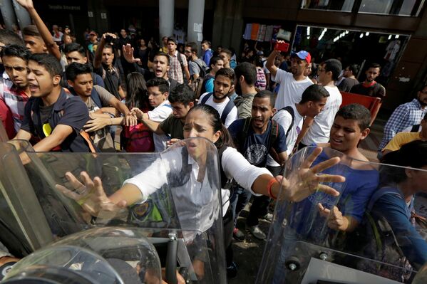 Столкновение сторонников оппозиции и спецподразделений полиции перед зданием суда в Каракасе, Венесуэла - Sputnik Грузия