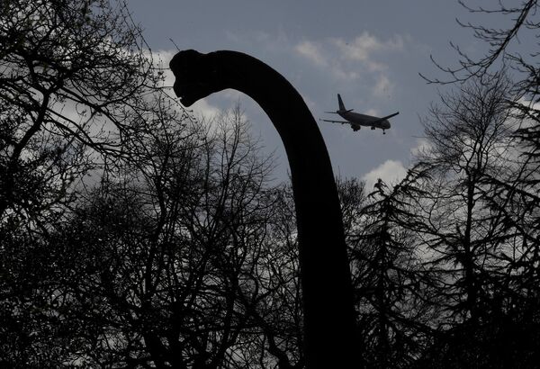 Что было бы, если бы динозавры жили сегодня? Пролетающий на фоне одной из фигур самолет дополняет произведенный эффект - Sputnik Грузия