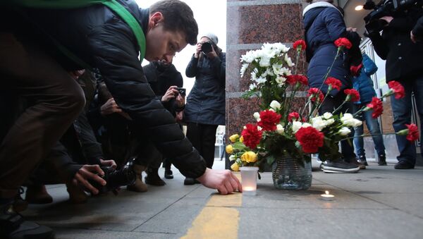 Люди возлагают цветы и зажигают свечи у входа на станцию метро Спасская в память о погибших в результате взрыва в метрополитене Санкт-Петербурга - Sputnik Грузия