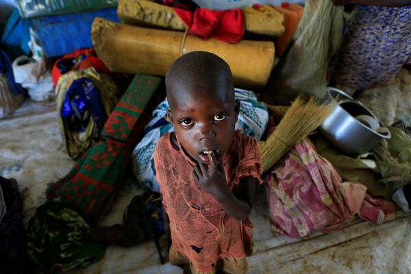 Мальчик-беженец из Южного Судана, который вместе со своей семьей бежал из города Пайок от продолжающихся в их стране боевых действий, разрушений и голода, на территорию Уганды. На фото - мальчик стоит рядом с вещами своей семьи в лагере в Ламво на севере Уганды - Sputnik Грузия