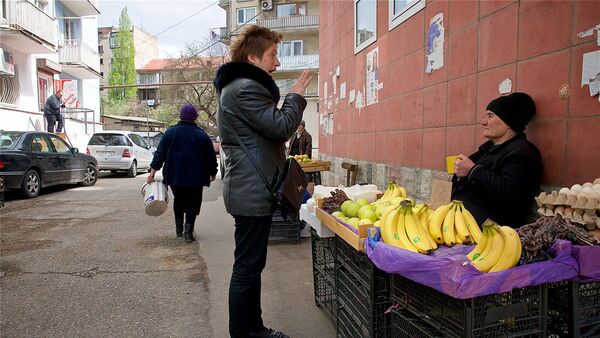 Женщина покупает овощи и фрукты у уличного торговца в центре грузинской столицы - Sputnik Грузия