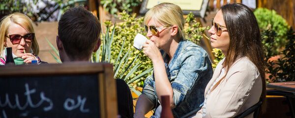 Девушки пьют кофе в уличном кафе в Тбилиси - Sputnik Грузия