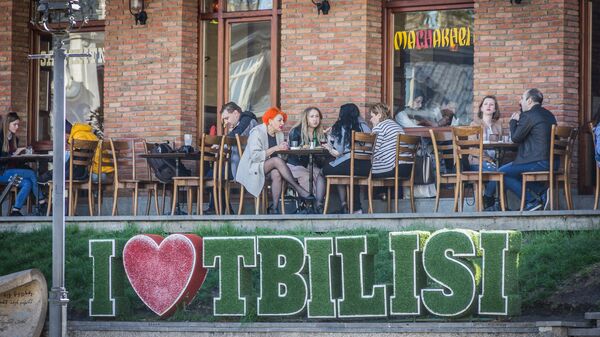 Посетители кафе сидят за столиками на улице - Sputnik Грузия