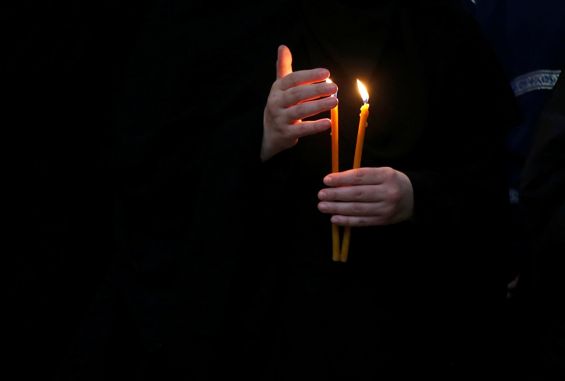 Мужчина ставит свечу. Свеча в руках. Человек со свечкой. Рука с церковной свечкой. Люди с свечами в церкви.