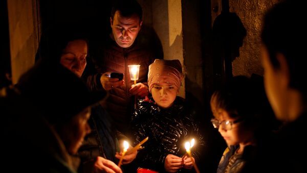 Православные верующие держат в руках зажженные свечи во время праздничной Пасхальной службы в кафедральном соборе Сиони - Sputnik Грузия