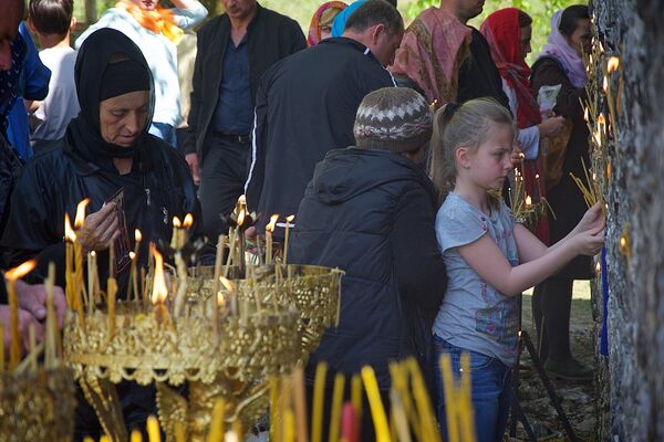 ეკლესიაში დიდი რაოდენობით ხალხი ვერ ეტევა, ამიტომ მორწმუნეები სანთლებს ტაძრის ეზოშიც ანთებენ - Sputnik საქართველო