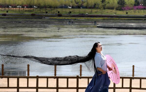 Девушка с длинными волосами позирует для фотографий в Вэйхае, провинция Шаньдун, Китай - Sputnik საქართველო
