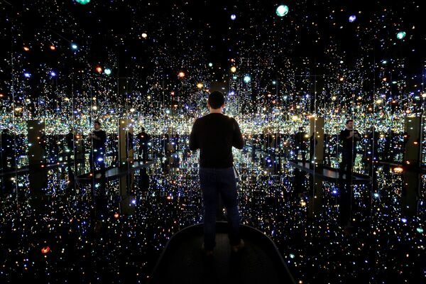 Человек осматривает выставку Бесконечная зеркальная комната - души за миллион световых лет японского художника Яёи Кусамы в музее Хиршхорна в Вашингтоне, США - Sputnik Грузия