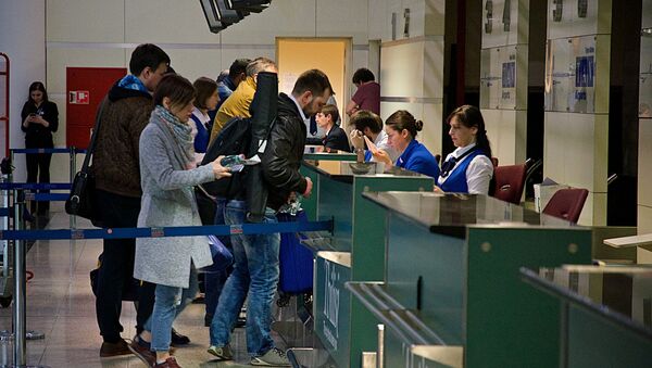 Туристы перед отлетом на стойке регистрации на рейс в Тбилисском международном аэропорту - Sputnik Грузия