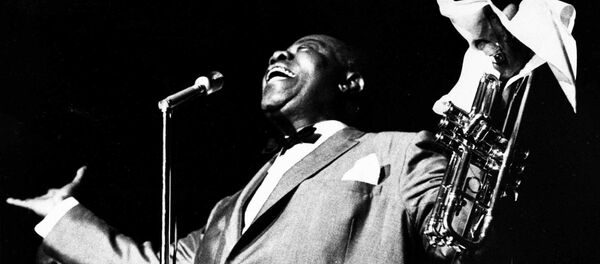 ჯაზმენი, რომელმაც ჯაზის განვითარებაზე დიდი ზეგავლენა იქონია, დაიბადა ახალი ორლეანის შავკანიანების ყველაზე ღარიბ რაიონში. პირველი მუსიკალური განათლება ლუი არმსტრონმა ფერადკანიანი არასრულწლოვნების გამოსასწორებელ კოლონიაში მიიღო, სადაც ის ახალ წელს იარაღის სროლის გამო აღმოჩნდა. ბანაკში ლუი ადგილობრივი ორკესტრის წევრი გახდა, სადაც ტამბურინზე, საყვირზე და კლარნეტზე დაკვრა ისწავლა. წარმატების მიღწევაში მას მუსიკისადმი სიყვარული და მიზანსწრაფულობა დაეხმარა. ფოტოზე: ლუი არმსტრონგი ჯაზ-ფესტივალზე ატლანტაში, 1966 წელი - Sputnik საქართველო