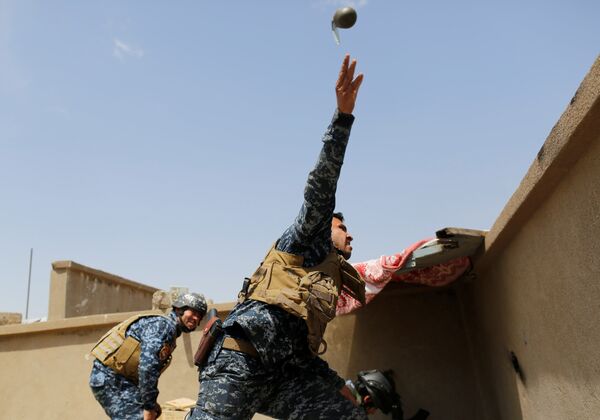 Сотрудник иракской федеральной полиции бросает ручную гранату во время столкновений с боевиками ИГИЛ в западном Мосуле, Ирак - Sputnik Грузия