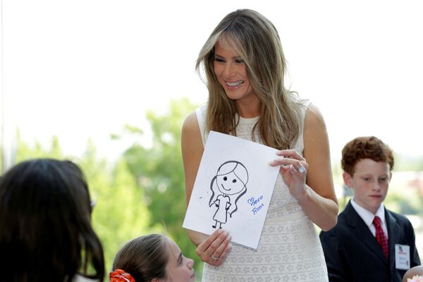 Первая леди США Мелания Трамп держит рисунок, подаренный ей ребенком в Национальном детском медицинском центре в Вашингтоне, США - Sputnik Грузия