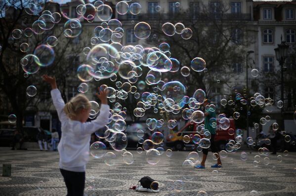 Уличный артист выступает с мыльными пузырями на площади Россио в центре Лиссабона, Португалия - Sputnik Грузия