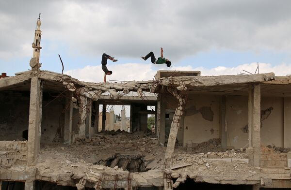 Ибрагим аль-Кадири (справа), 19, и Муханнадом аль-Кадири, 18, демонстрируют свои навыки в паркуре на поврежденных зданиях в городе Инхил, Сирия - Sputnik Грузия