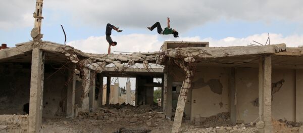 Ибрагим аль-Кадири (справа), 19, и Муханнадом аль-Кадири, 18, демонстрируют свои навыки в паркуре на поврежденных зданиях в городе Инхил, Сирия - Sputnik Грузия