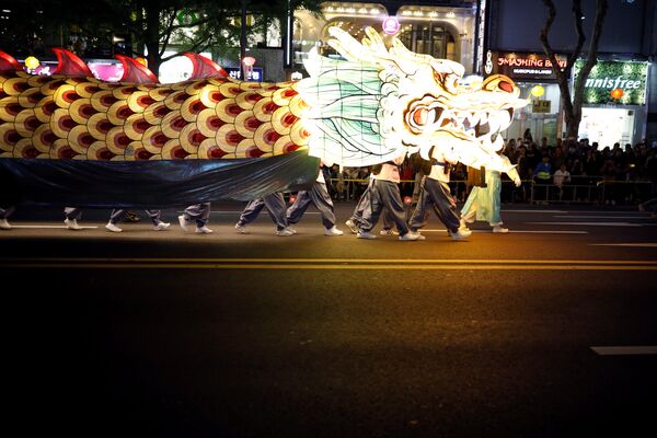 Буддийские верующие несут гигантского огненного дракона по улицам Сеула, празднуя День рождения Будды. В Южной Корее этот праздник потом длится целый месяц - столько времени висят на улицах корейских городов праздничные украшения и фонарики - Sputnik Грузия