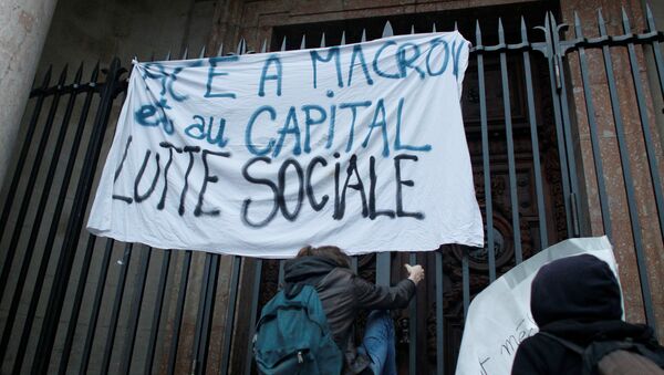 Демонстранты держат плакат с лозунгом Социальная борьба после объявления победы Эммануэля Макрона на выборах президента Франции - Sputnik Грузия