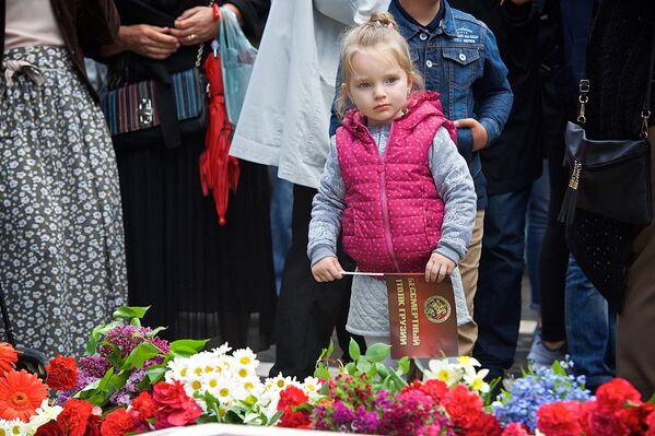 Маленькая девочка держит в руках флажок с символикой Бессмертного полка - активисты акции раздали около 500 таких флажков в парке во время проведения праздничных мероприятий 9 мая - Sputnik Грузия