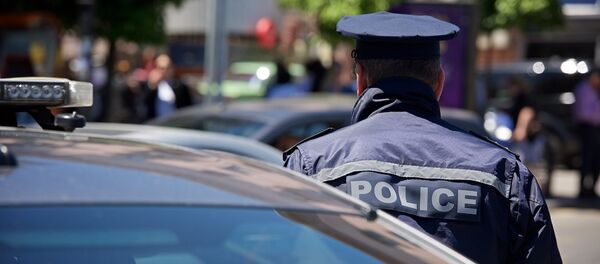 Сотрудник патрульной полиции в оцеплении - Sputnik Грузия