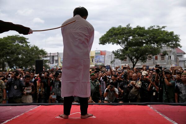 В Индонезии публично высекли двух геев. Экзекуция проводилась возле одной из мечетей города Банда-Ачех. Каждый из осужденных получил по 82 удара розгой. За этим наблюдали около тысячи местных жителей - Sputnik Грузия