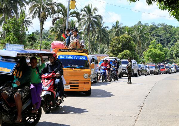 Очередь из автомобилей, на которых жители Марави покидают город, захваченный боевиками ИГ. Фото сделано на военном контрольно-пропускном пункте в городе Пантар, Филиппины - Sputnik Грузия