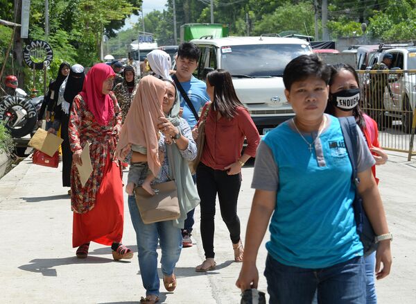 Жители Марави, которые покинули город после его захвата боевиками ИГ, проходят через контрольно-пропускной пункт на въезде в Илиган, Филиппины - Sputnik Грузия