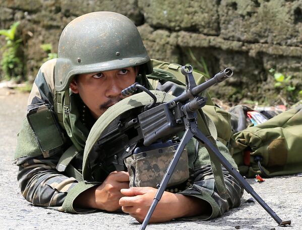 Один из солдат филиппинской армии на позиции, откуда ведется штурм укреплений боевиков ИГ в городе Маравиф - Sputnik Грузия