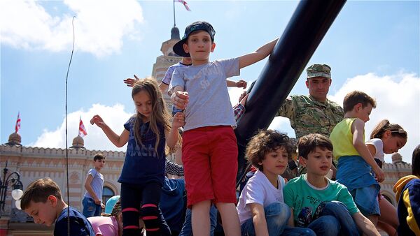 Дети на самоходной артиллерийской установке Dana фотографируются на память во время выставки вооружений в День Независимости Грузии - Sputnik Грузия