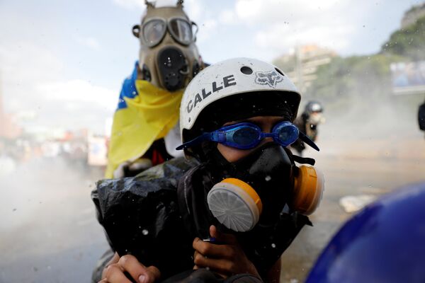 Столкновения протестующих с силами безопасности во время демонстрации против президента Николаса Мадуро в Каракасе, Венесуэла - Sputnik Грузия