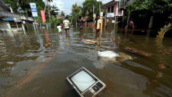 Телевизор плавает на затопленной дороге в деревне Додангода в Калутара, Шри-Ланка - Sputnik Грузия