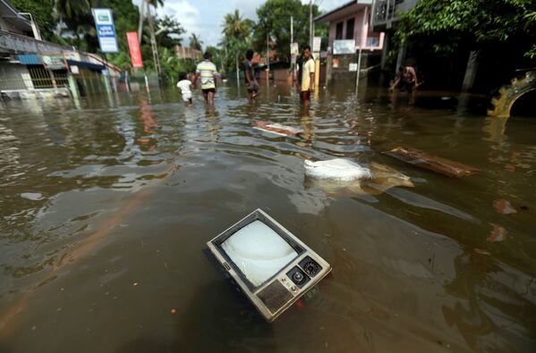 Вода вынесла из затопленных домов жителей Шри-Ланки личные вещи, мебель, кухонную утварь. На фото - телевизор плавает на затопленной дороге в деревне Додангода в Калутаре - Sputnik Грузия